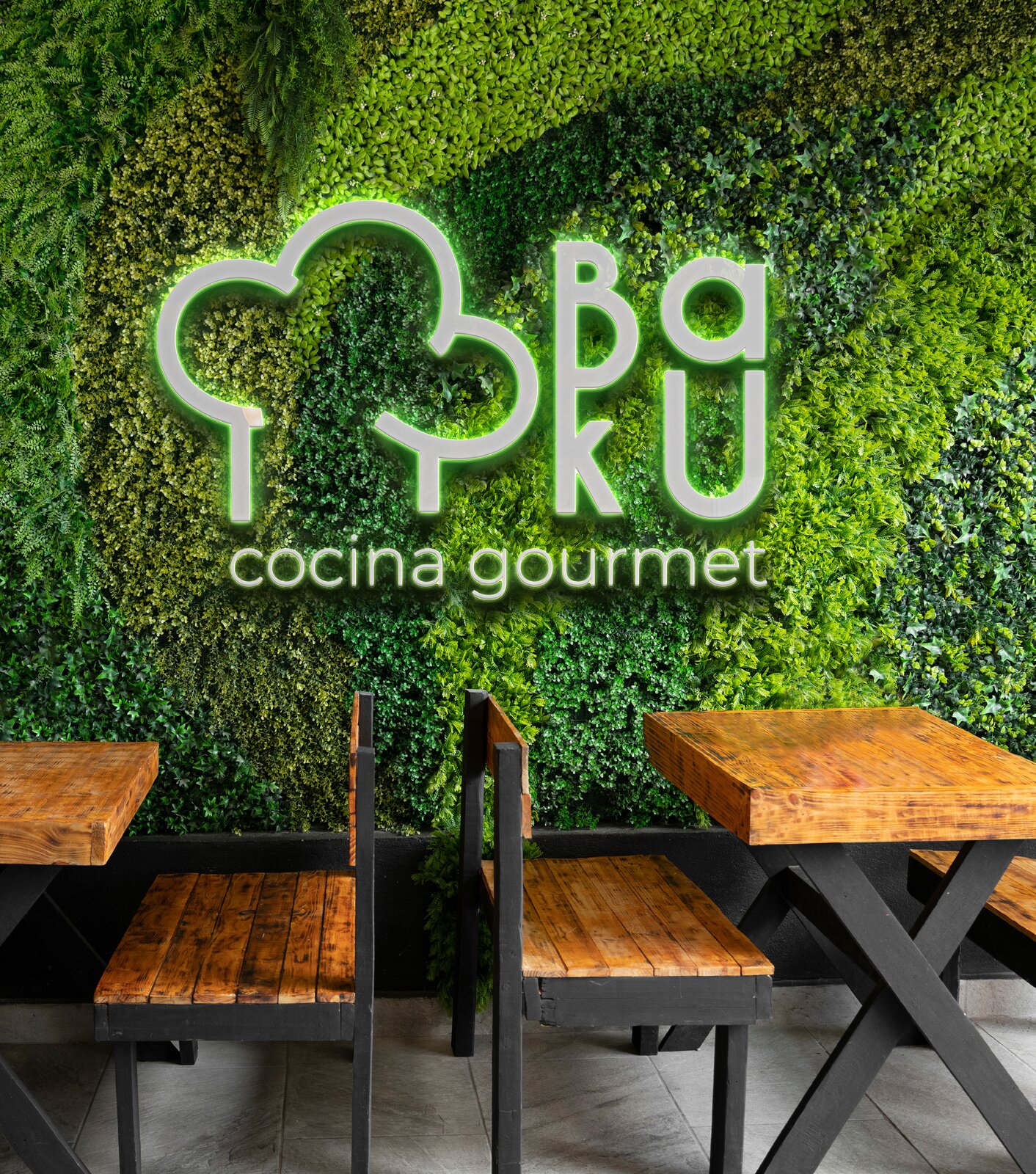 Interior de Baku Cocina Gourmet con pared verde y logo