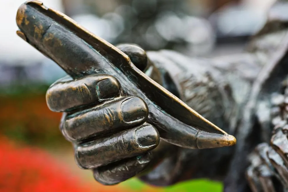 Detalle de una escultura de bronce que sostiene una navaja, símbolo de la tradición cuchillera de Albacete