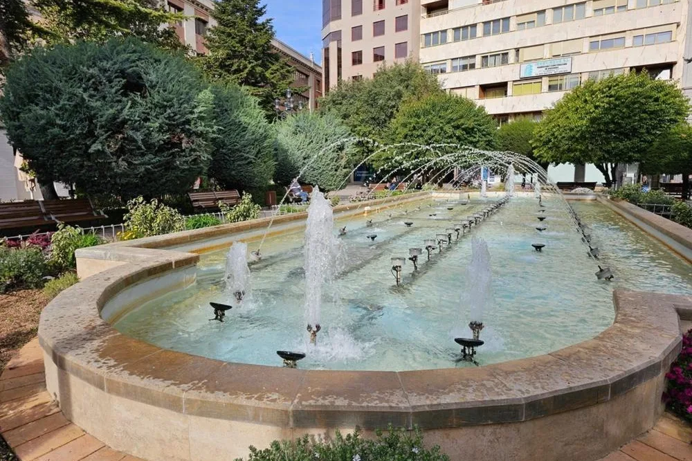 Fuente ornamental con chorros de agua en una plaza ajardinada del centro de Albacete
