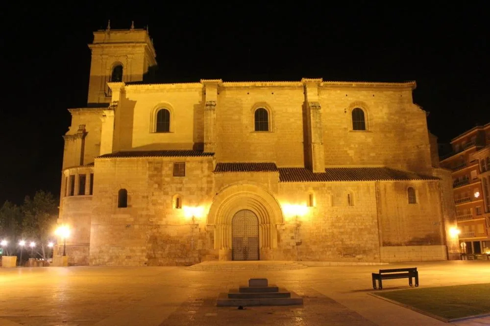 Templo histórico de piedra iluminado de noche en una plaza de Albacete